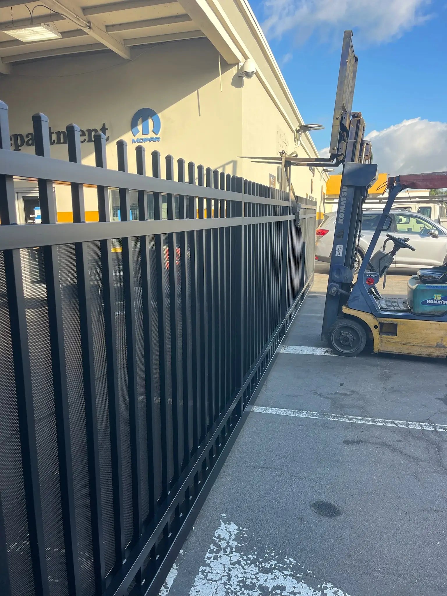 Iron Master crew installing a commercial driveway gate for Orange Coast Chrysler Jeep Dodge Ram Fiat
