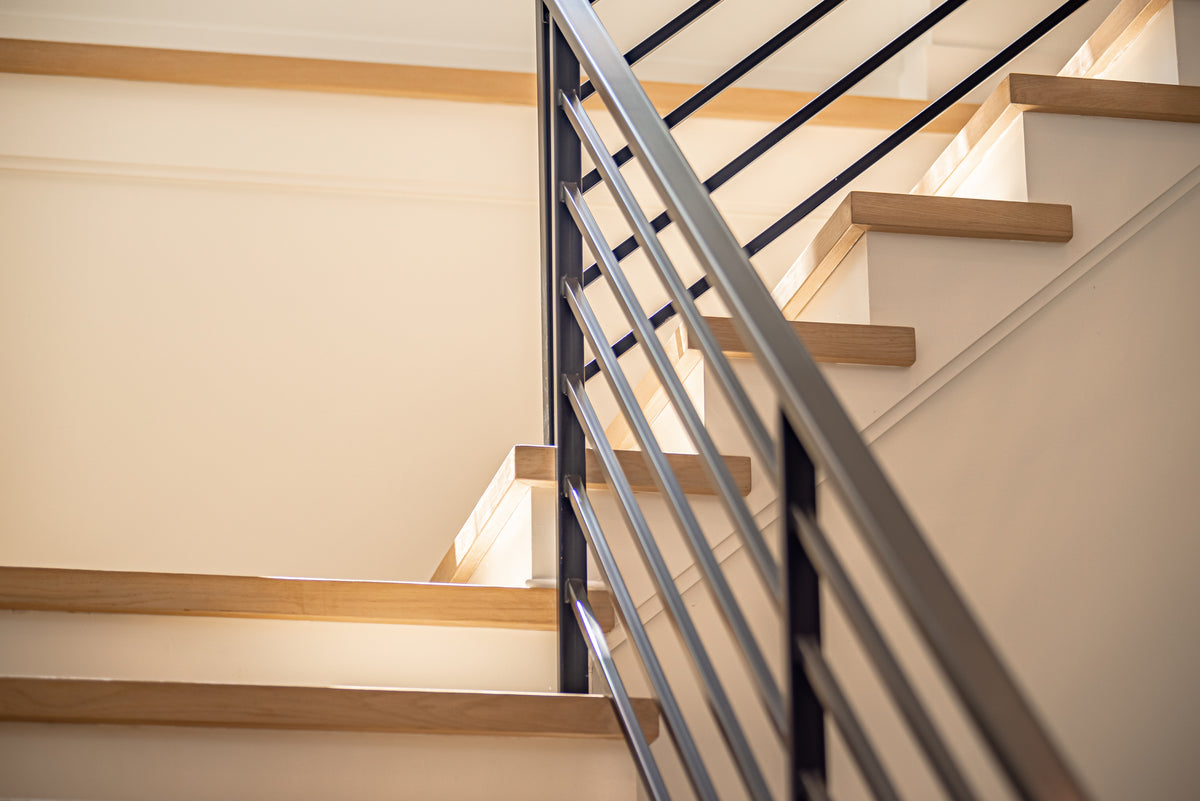 Wooden staircase with metal railing in a well-lit room